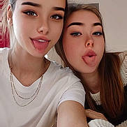 Mya participe au concours pour gagner de l'argent avec cette photo : two_people, female, young_women, selfie, tongue_out, playful, casual_clothing, white_tshirt, knit_sweater, indoor, portrait, face, smile, long_hair, necklace, red_curtain, light_skin, brown_hair, eyebrows, cheeky