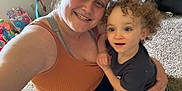 Hansel is registered to the contest to win money with this photo: affection, candid, carpet, casual_clothing, child, childhood, colorful, curly_hair, family, happy, home, indoor, interaction, living_room, person, playtime, smiling, toddler, toys, woman