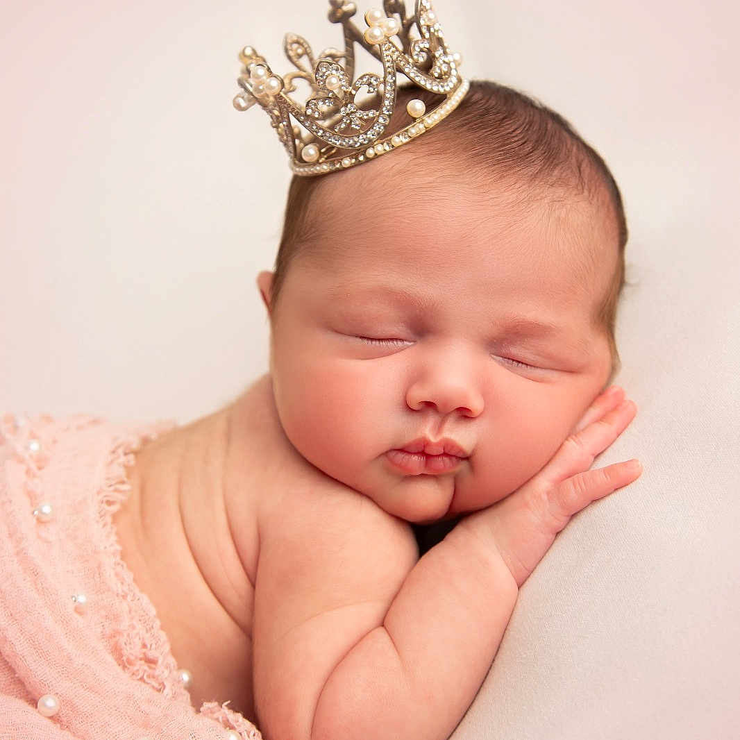 Lanelle is registered to the contest to win money with this photo: newborn, baby, sleeping, crown, pink_cloth, pearl, infant, portrait, soft_skin, cute, peaceful, resting, head, hand, closeup, adorable, sleep, baby_wrapped, tiny, child