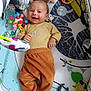 baby, smiling, playpen, toy, colorful, soft_toy, blanket, infant, child, clothing, happy, lying_down, indoor, comfort, cute, playtime, small_person, fabric, pajamas, head