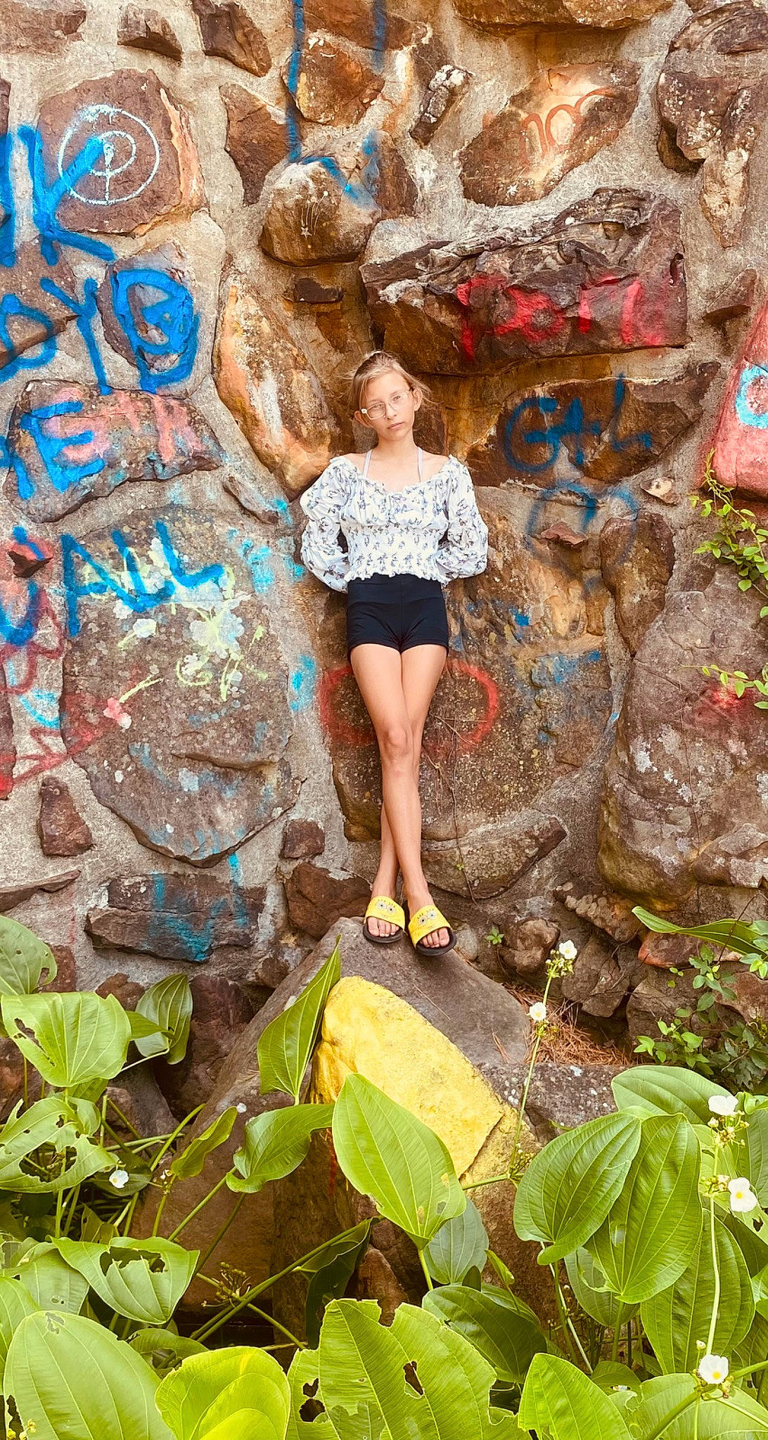 Peyton is registered to the contest to win money with this photo: adventure, bedrock, electric_blue, fun, grass, jungle, landscape, leg, leisure, organism, outcrop, people_in_nature, person, plant, recreation, rock, t_shirt, thigh, tourism, visual_arts