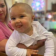 éva a rejoint le concours — aidez-le/la à gagner de superbes lots ! baby, blurred_background, child, cute, expression, face, hand, head, holding, human, indoor, infant, light, person, pink_clothing, skin, smiling, tongue_out, white_clothing, woman