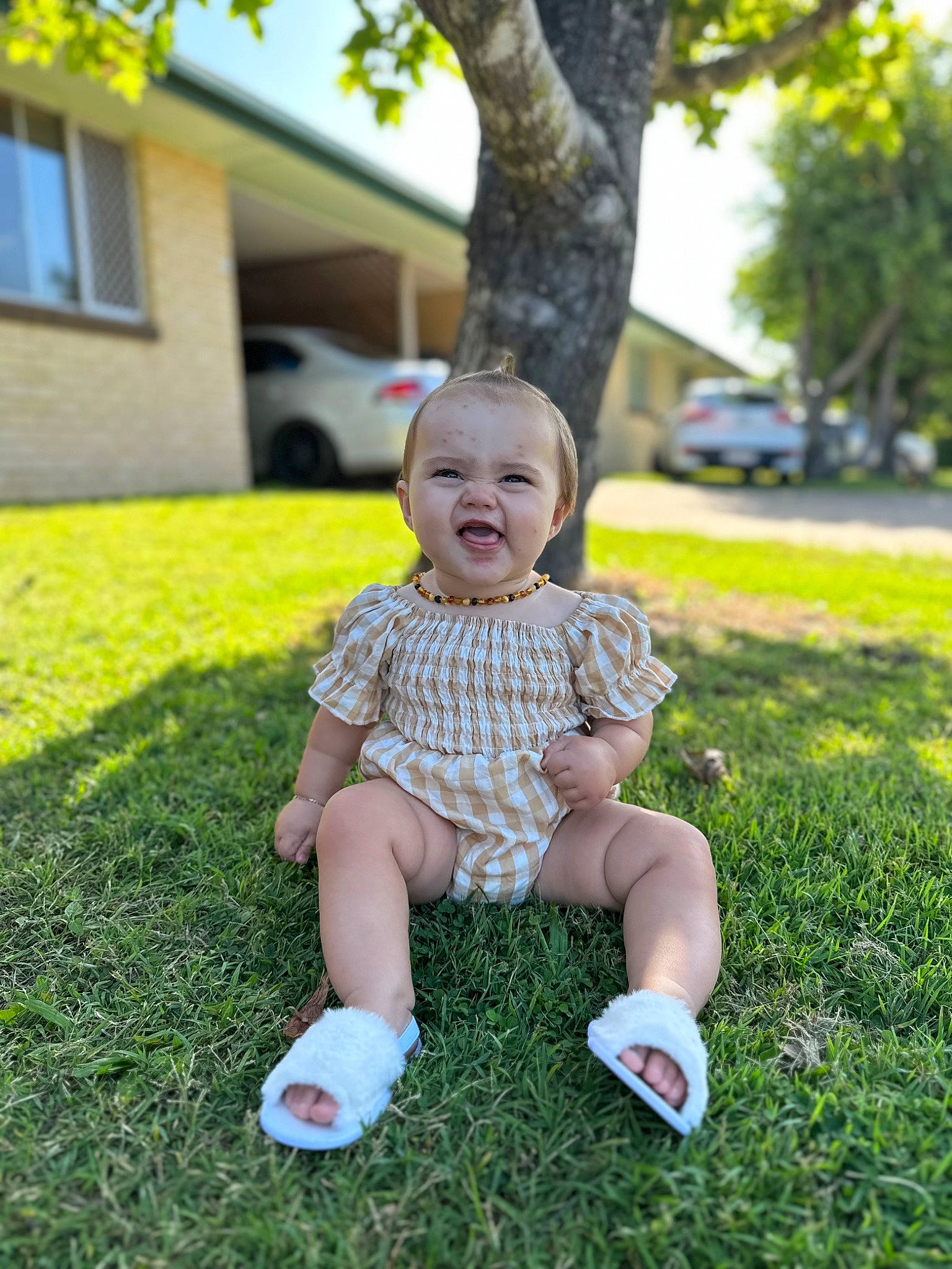 Addilynn is registered to the contest to win money with this photo: baby, baby_toddler_clothing, blond, finger, fun, grass, happy, lawn, leisure, people_in_nature, person, plant, recreation, sitting, smile, sneakers, t_shirt, toddler, tree, window
