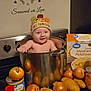 baby, child, kitchen, cooking_pot, onions, potatoes, canned_food, spices, instant_mashed_potatoes, stove, hat, thanksgiving, smiling, wall_decal, indoor, food, cute, person, appliance, happy