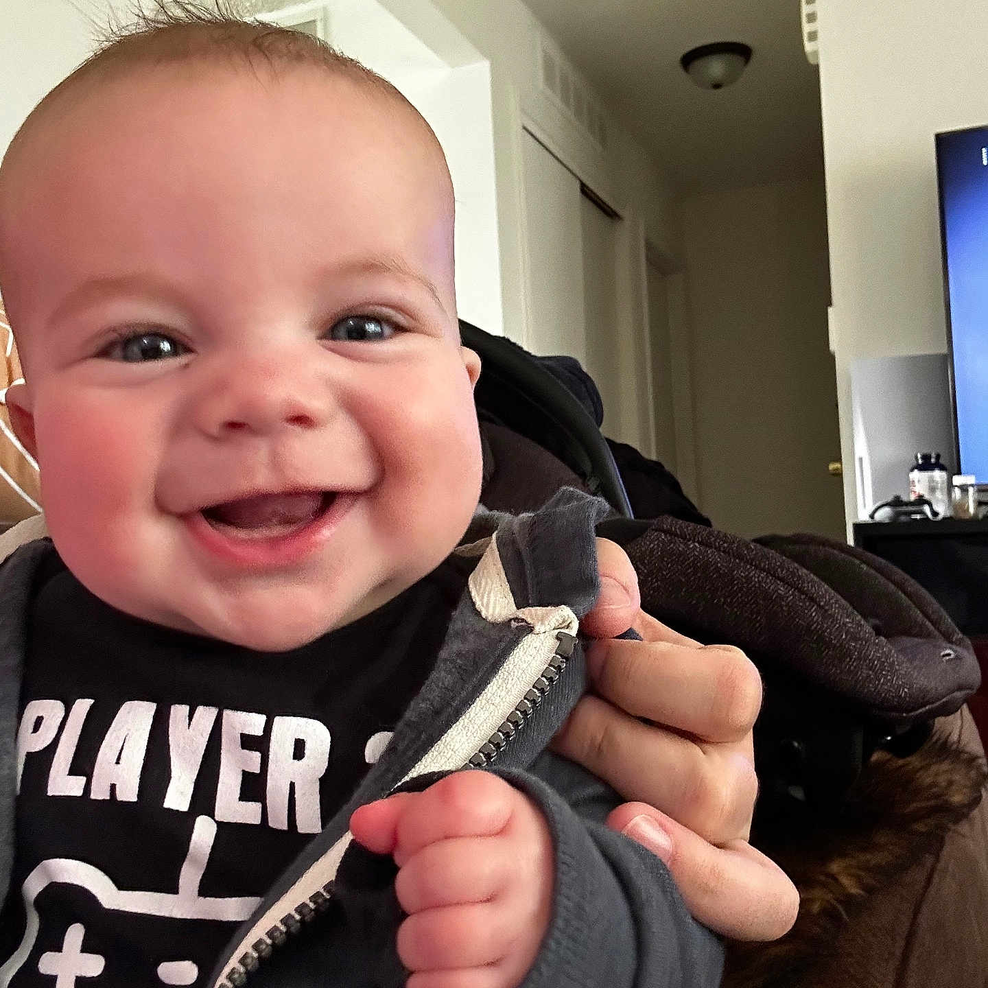 Nico is registered to the contest to win money with this photo: baby, babylaughing, bodypart, clothing, coat, computerhardware, electronics, face, finger, hand, happy, hardware, head, jacket, lamp, monitor, person, photography, portrait, screen
