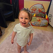 éden a rejoint le concours — aidez-le/la à gagner de superbes lots ! barefoot, carpet, child, curly_hair, curtains, cute, furniture, happy, home, indoor, person, play_tent, radiator, rug, smiling, striped_shirt, toddler, toy, winnie_the_pooh, young_child