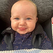 Maddox is registered to the contest to win money with this photo: baby, blanket, blue_eyes, car_seat, child, closeup, clothing, cute, face, happy, head, indoors, infant, person, portrait, seatbelt, smiling, straps, tongue, young