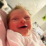 Hazel is registered to the contest to win money with this photo: baby, smiling, infant, pink_clothing, happy, portrait, face, human, child, indoors, soft_light, newborn, cute, cozy, toddler, expression, skin, hair, person, warmth