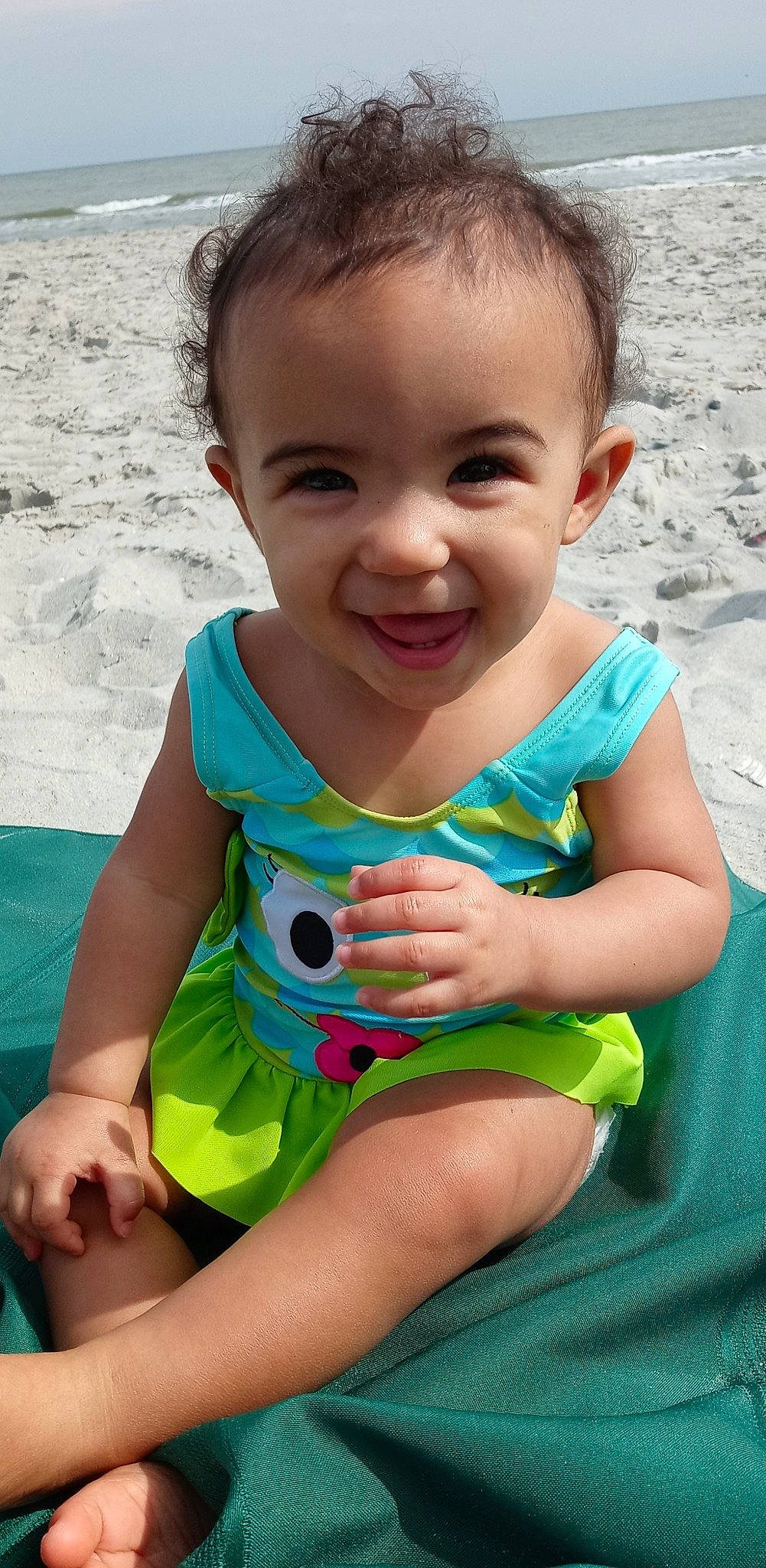 Talia is registered to the contest to win money with this photo: active_tank, aqua, baby, baby_products, baby_toddler_clothing, child, face, finger, hand, joy, mouth, nose, person, sitting, skin, summer, toddler, vacation