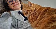 Suko participe au concours pour gagner de l'argent avec cette photo : cat, orange_cat, woman, person, glasses, portrait, selfie, couch, indoors, relaxing, cuddling, pet, furry, tabby, ginger, whiskers, ears, shirt, home, close_up