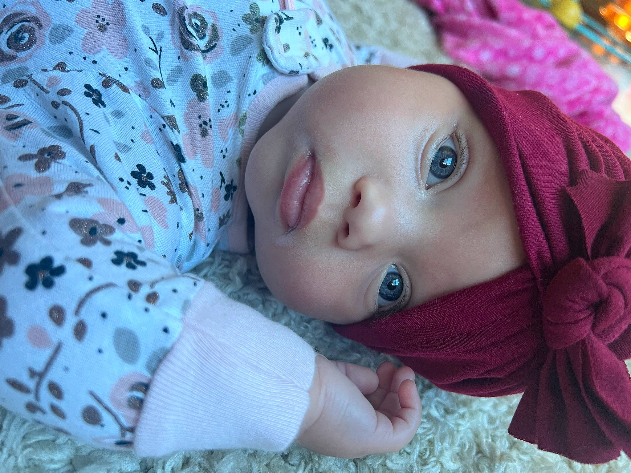 Tatum is registered to the contest to win money with this photo: baby, baby_toddler_clothing, cap, cheek, child, dress, eye, eyelash, grass, head, headwear, iris, lip, nose, outerwear, pattern, person, purple, skin, sleeve