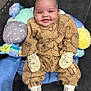 Romeo joined the competition — help win amazing prizes! baby, infant, smile, mittens, socks, plush_toys, cushion, chair, brown_outfit, cute, happy, child, indoor, soft_toys, face, person, seated, comfort, warm_clothing, adorable