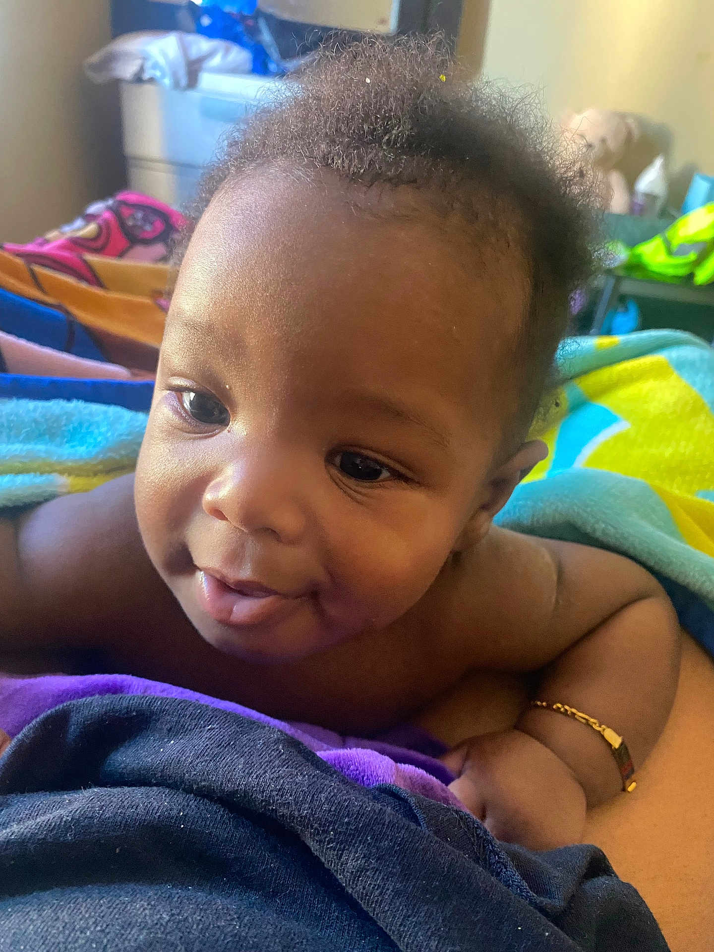 Kamari joined the competition — help win amazing prizes! baby, smiling, close_up, curly_hair, bracelet, blanket, colorful, skin, infant, portrait, child, happy, indoors, person, cute, young, lying_down, soft_light, warm, cozy