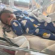 Josiah joined the competition — help win amazing prizes! baby, infant, hospital, incubator, medical_tape, blue_onesie, cloud_pattern, sun_pattern, blanket, medical_equipment, no_smoking_sign, newborn, premature_baby, crib, healthcare, patient, child, person, indoor, care