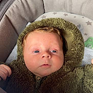 Teddy joined the competition — help win amazing prizes! baby, infant, child, fuzzy_clothing, hood, bassinet, blanket, cushion, blue_eyes, face, hand, zipper, soft_texture, indoor, resting, cute, newborn, sleepwear, star_pattern, portrait