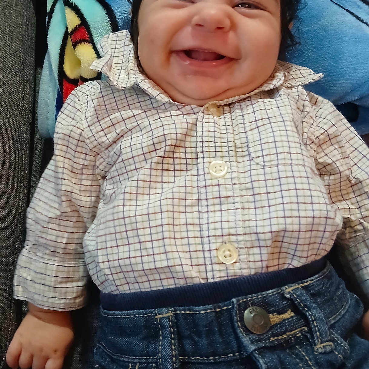 Liam Carracedo joined the competition — help win amazing prizes! baby, blanket, cheeks, child, clothing, couch, cute, denim, happy, home, indoor, infant, lying_down, pants, person, portrait, relaxing, remote_control, shirt, smiling