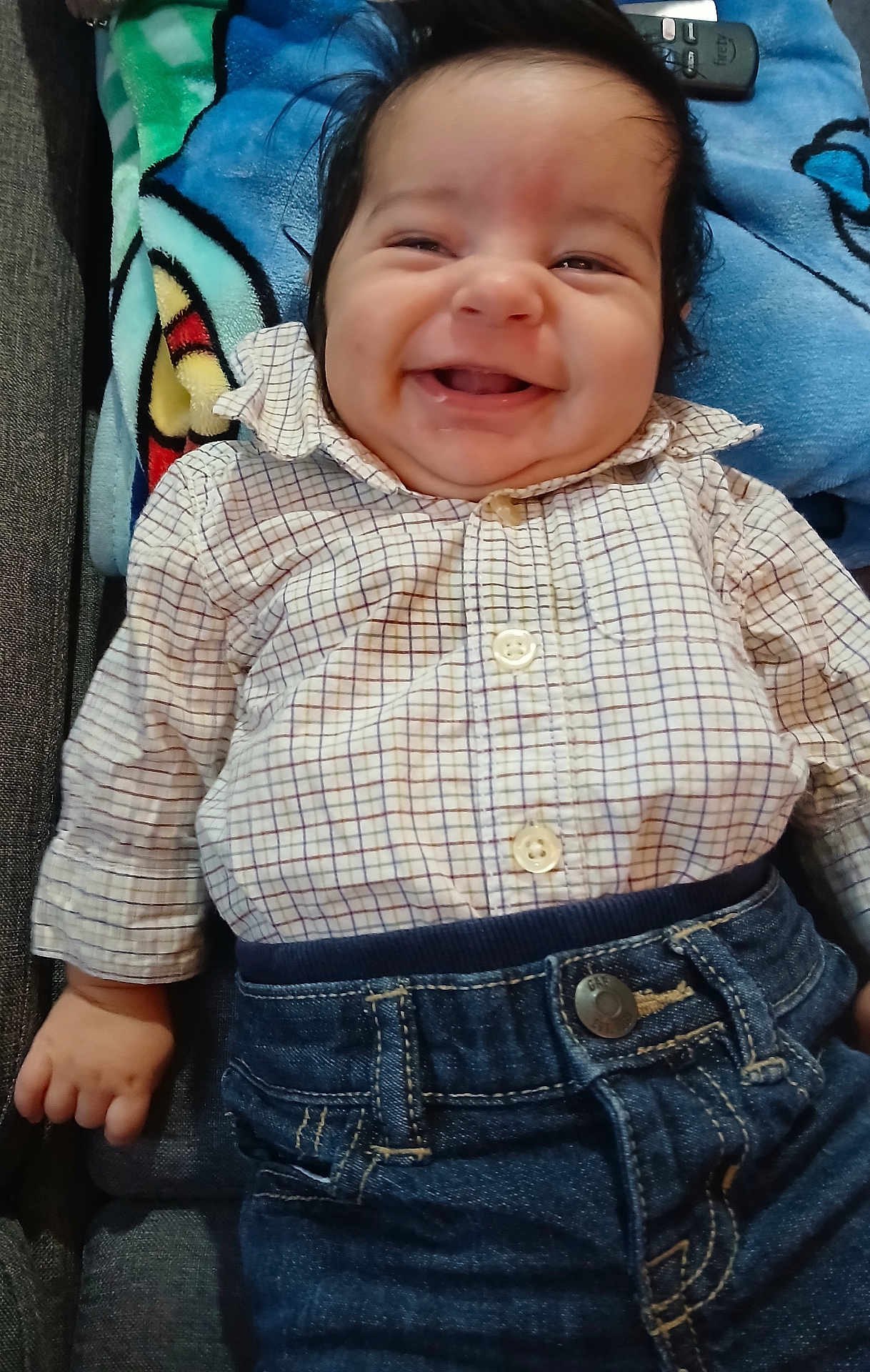 Liam Carracedo joined the competition — help win amazing prizes! baby, blanket, cheeks, child, clothing, couch, cute, denim, happy, home, indoor, infant, lying_down, pants, person, portrait, relaxing, remote_control, shirt, smiling