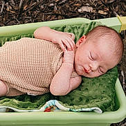 Brooks joined the competition — help win amazing prizes! baby, newborn, sleeping, basket, green, blanket, outdoor, nature, woodchips, rock, infant, peaceful, resting, cute, child, person, skin, head, hands, cozy