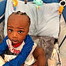 Zyair Marshall is registered to the contest to win money with this photo: toddler, child, baby, playpen, toys, blanket, clothing, person, indoor, curious, expression, braids, soft, colorful, comfort, infant, looking_up, cute, young, exploration
