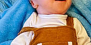 Dale is registered to the contest to win money with this photo: baby, infant, child, smiling, clothing, overall, hat, blanket, blue, white, happy, face, headwear, soft, cute, lying_down, indoors, person, small_hand, young