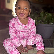 Juanita joined the competition — help win amazing prizes! toddler, child, smiling, pink_pajamas, indoor, glass_table, plant, happy, cute, sitting, portrait, face, person, home, cozy, baby, clothing, feet, tongue_out, playful