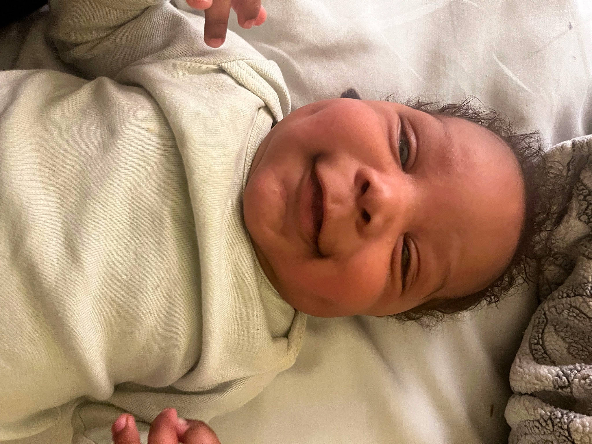 Isiah is registered to the contest to win money with this photo: baby, baby_toddler_clothing, cheek, child, chin, comfort, eyebrow, eyelash, face, finger, happy, head, linens, lip, mouth, nose, person, skin, sleeve, smile
