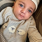 Aidan joined the competition — help win amazing prizes! baby, child, blue_eyes, striped_clothing, sheep_embroidery, cap, portrait, close_up, infant, cute, face, person, young_child, lying_down, comfort, texture, fabric, soft_lighting, indoor, expression