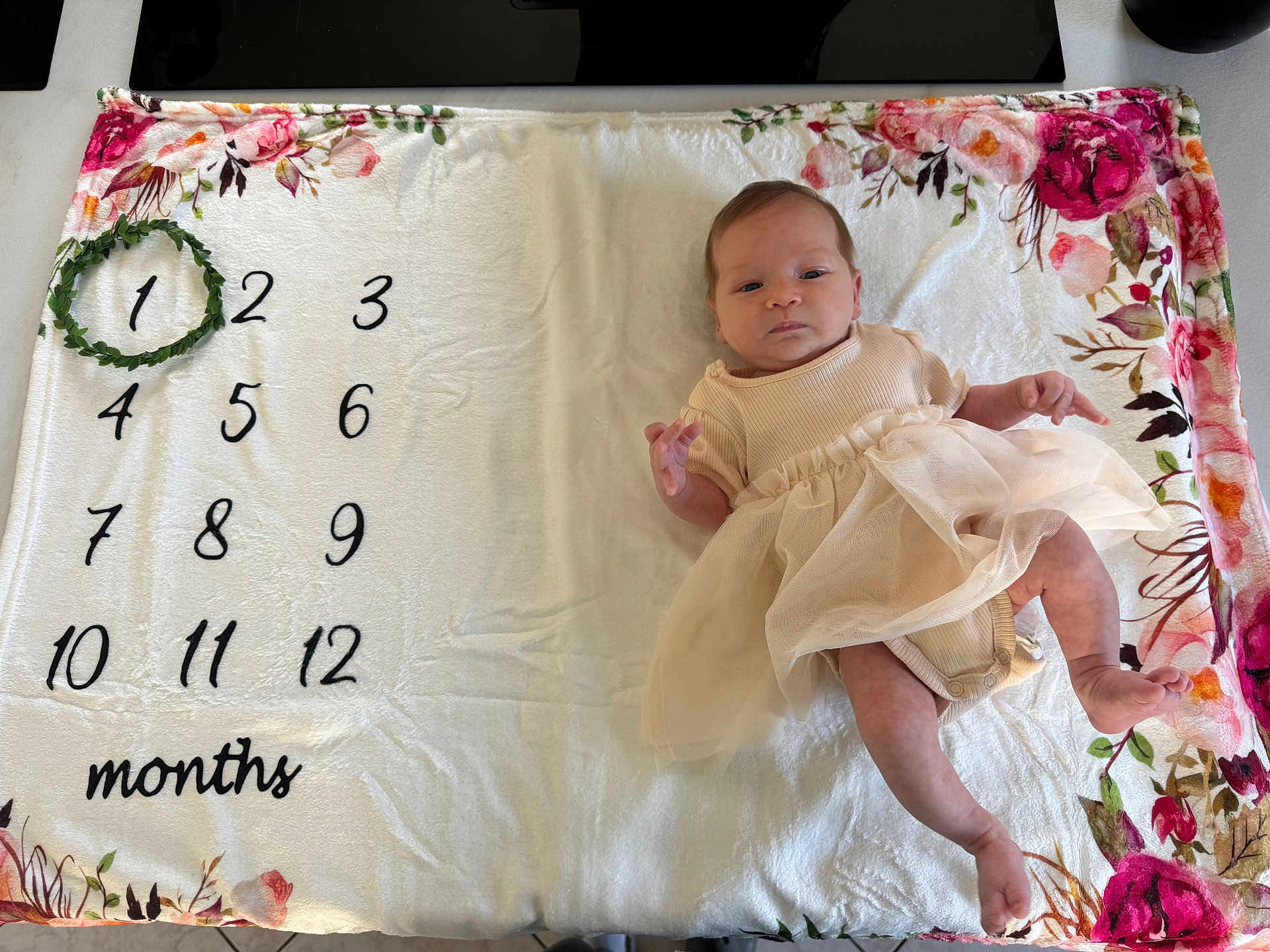 Emmé a rejoint le concours — aidez-le/la à gagner de superbes lots ! baby, infant, dress, blanket, floral, months, wreath, milestone, laying, cute, newborn, soft, pattern, celebration, child, person, indoors, skin, foot, hand