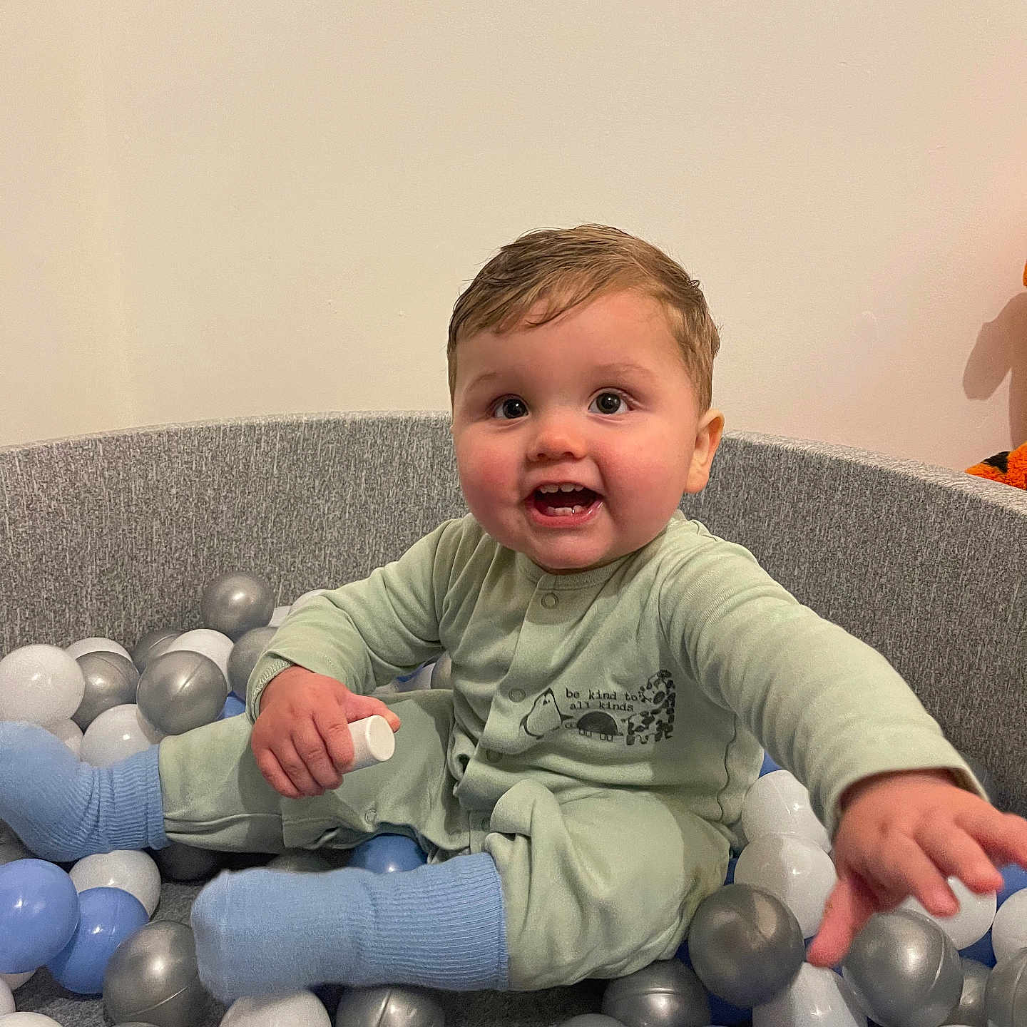 Tommy is registered to the contest to win money with this photo: accessories, baby, balloon, bodypart, clothing, couch, face, finger, furniture, hand, happy, head, pants, person, photography, playarea, portrait, sitting, smile, sphere