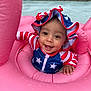 Raylynn is registered to the contest to win money with this photo: baby, child, smiling, face, hat, swimsuit, inflatable, pool, water, float, pink, stars, stripes, patriotic, happy, summer, outdoor, droplets, person, infant