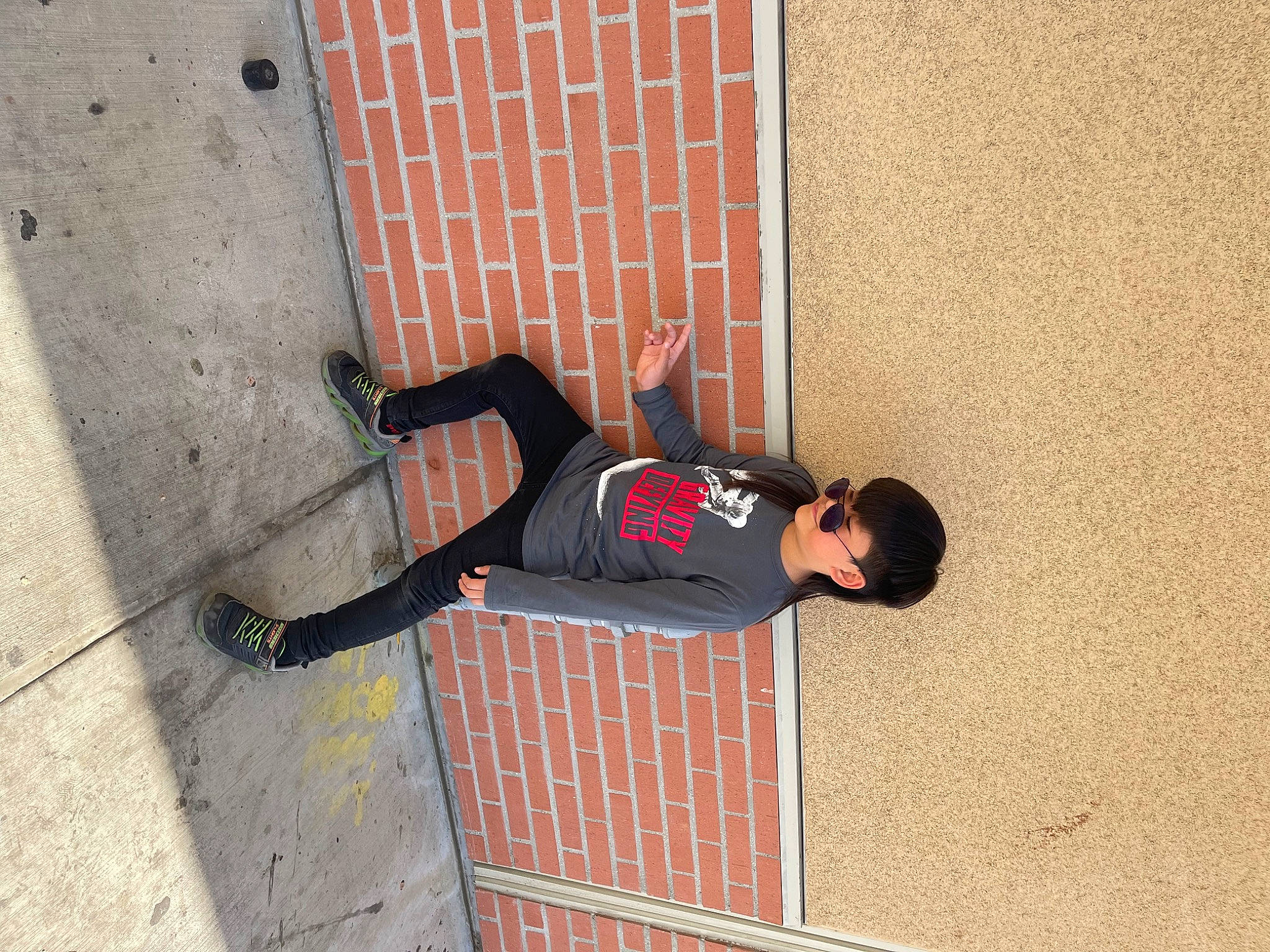 Chris Trevor Dela Cruz is registered to the contest to win money with this photo: brick, brickwork, carmine, concrete, facade, flooring, foot, human_leg, knee, outdoor_shoe, pedestrian, person, road_surface, shadow, sidewalk, sitting, street, street_fashion, thigh, walking_shoe