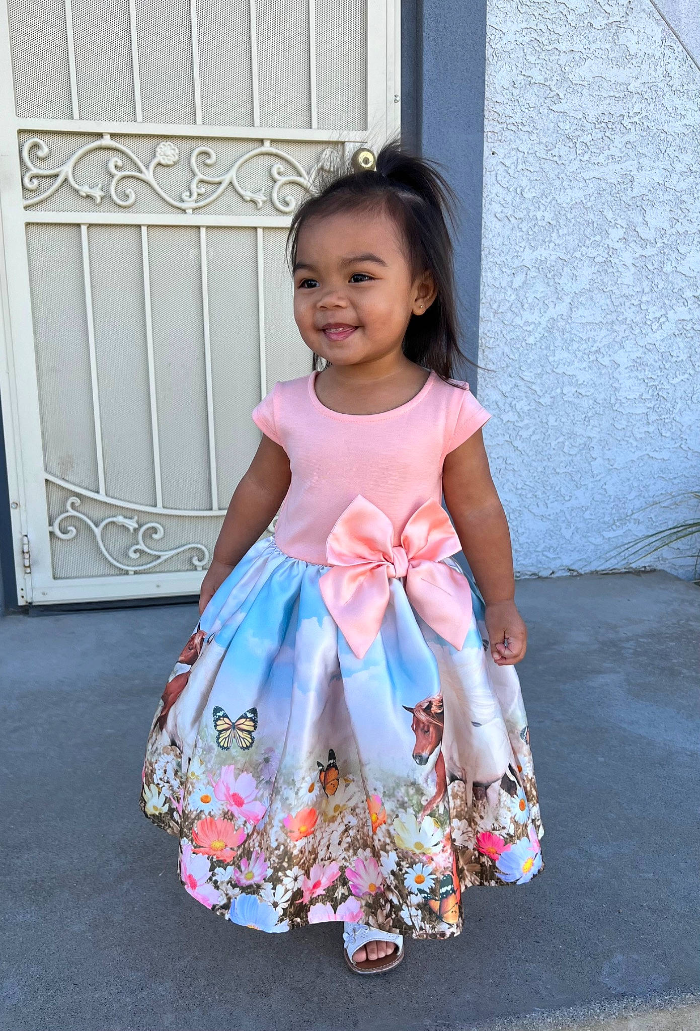 Inez is registered to the contest to win money with this photo: baby_toddler_clothing, child, day_dress, dress, electric_blue, embellishment, event, fashion_design, formal_wear, happy, joy, magenta, one_piece_garment, pattern, peach, person, pink, ruffle, sleeve, smile