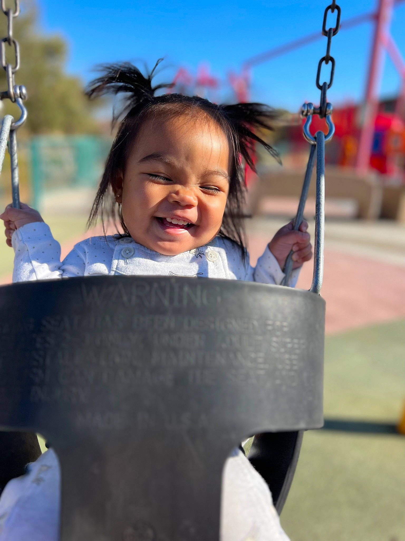 Inez joined the competition — help win amazing prizes! beauty, child, city, facial_expression, fun, grass, hair, happy, human_settlement, leisure, outdoor_play_equipment, person, playground, public_space, recreation, skin, sky, smile, swing, toddler