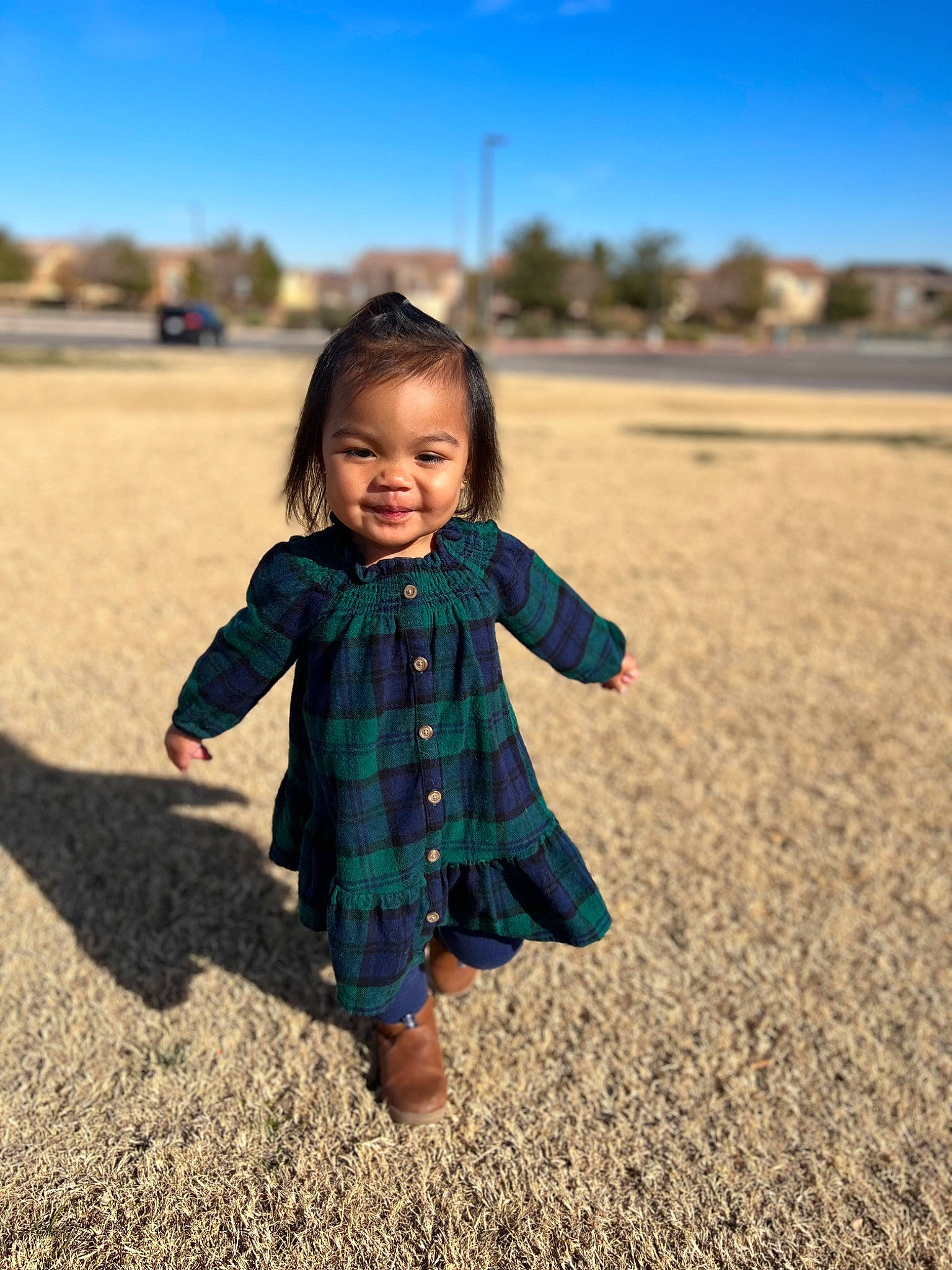 Inez joined the competition — help win amazing prizes! azure, body_of_water, eye, fun, grass, grassland, happy, head, joy, landscape, leisure, natural_environment, outerwear, people_in_nature, person, plaid, plant, sky, smile, toddler