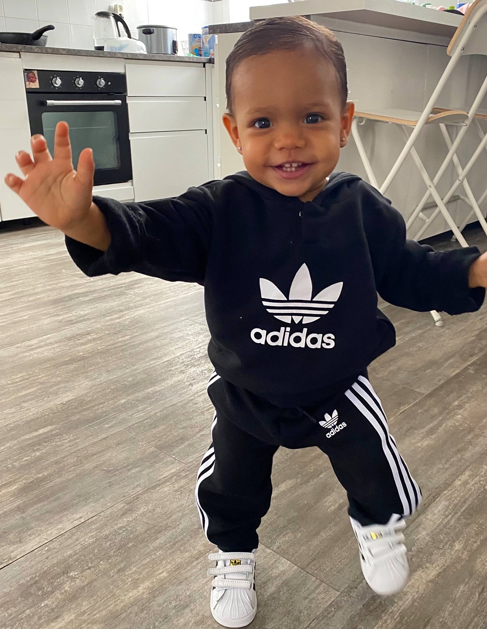 Eris participe au concours pour gagner de l'argent avec cette photo : baby_toddler_clothing, facial_expression, finger, floor, flooring, gesture, hand, happy, home_appliance, joint, joy, outerwear, person, product, shoulder, skin, sleeve, smile, standing, t_shirt