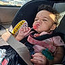 Tirzah is registered to the contest to win money with this photo: baby, child, infant, car_seat, car, lollipop, candy, smiling, face, curly_hair, earring, pink_clothing, seatbelt, safety_harness, pacifier, indoor, vehicle, sunlight, portrait, outdoor_background