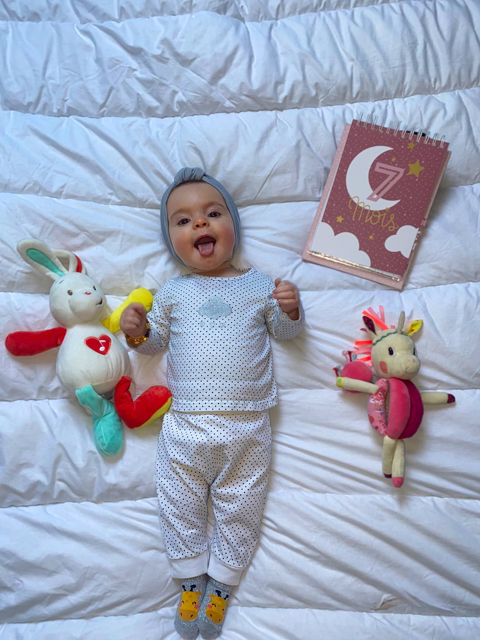 Layanna a rejoint le concours — aidez-le/la à gagner de superbes lots ! baby, baby_toddler_clothing, bedding, child, comfort, flooring, fun, happy, linens, pattern, person, pillow, product, room, sleeve, smile, stuffed_toy, textile, throw_pillow, toddler
