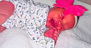 Saraphina is registered to the contest to win money with this photo: baby, newborn, infant, sleeping, onesie, headband, bow, pink, blanket, soft, cozy, cute, pattern, floral, hand, face, peaceful, indoors, portrait, child