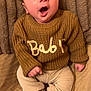 baby, infant, child, knitted_sweater, sweater, yawning, open_mouth, face, eyes, hands, legs, socks, pants, corduroy_pants, blanket, couch, cozy, portrait, home_interior, soft_texture