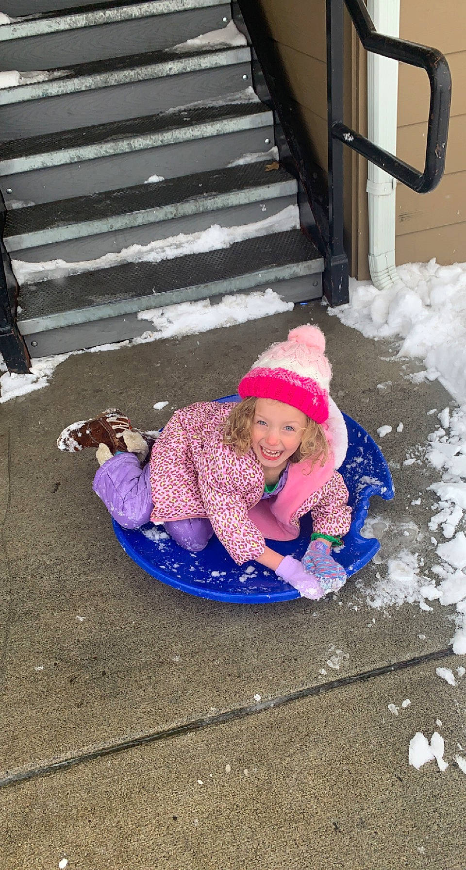Aly is registered to the contest to win money with this photo: baby_toddler_clothing, child, electric_blue, freezing, fun, headwear, jacket, joy, knit_cap, leisure, magenta, pattern, person, pink, play, public_space, purple, recreation, sitting, smile