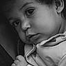 baby, black_and_white, candid, child, close_up, clothing, curly_hair, emotion, expression, face, hand, innocence, intimate, monochrome, portrait, resting, skin, soft_light, texture, young