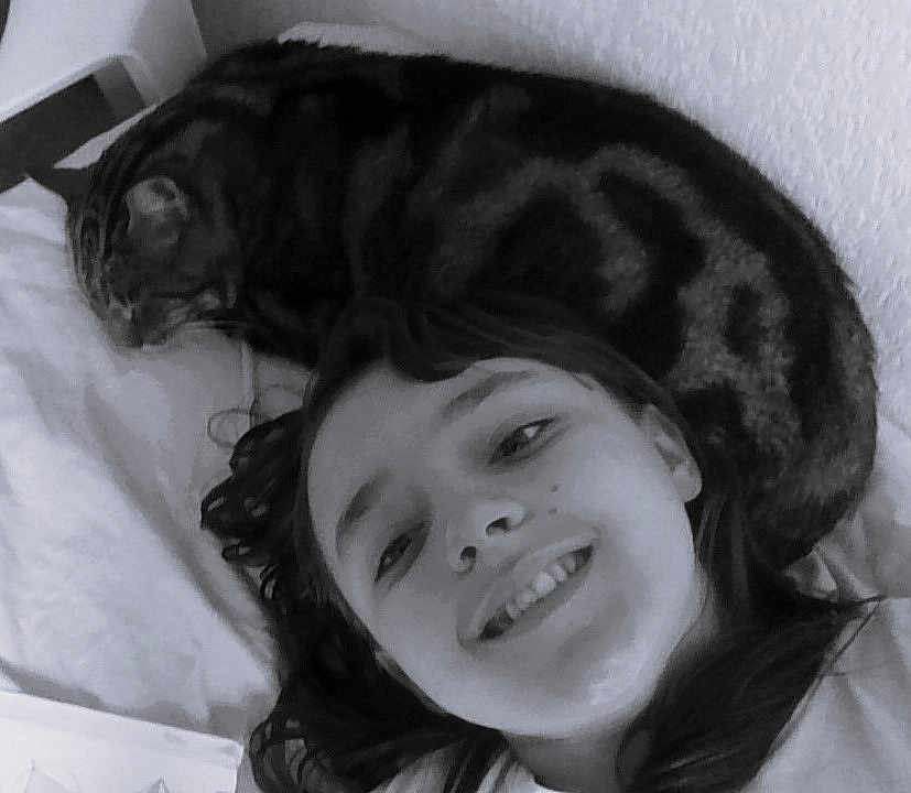Larry a rejoint le concours — aidez-le/la à gagner de superbes lots ! child, smile, face, cat, pet, lying_down, bed, blanket, hair, indoor, animal, feline, resting, cozy, black_and_white, portrait, happy, young, relaxing, closeup