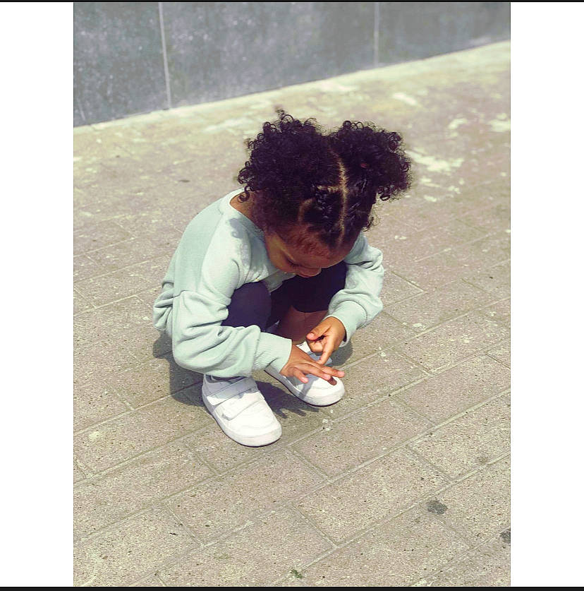 Inahya Penda participe au concours pour gagner de l'argent avec cette photo : asphalt, denim, flooring, fur, grass, happy, human_leg, outerwear, person, play, recreation, road_surface, sidewalk, sitting, sleeve, soil, square, stock_photography, street_fashion, toddler