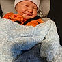 Caolan joined the competition — help win amazing prizes! baby, blanket, hat, orange_clothing, smile, infant, car_seat, cozy, sleepy, cute, child, soft_texture, wrapped, newborn, face, headwear, infant_clothing, relaxed, indoors, comfort