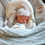 Caolan is registered to the contest to win money with this photo: baby, newborn, sleeping, hat, mittens, blanket, baby_seat, cushion, soft, cozy, indoor, child, infant, peaceful, cute, warm, comfortable, portrait, resting, tiny