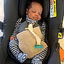baby, car_seat, sleeping, pajamas, striped_clothing, blanket, pacifier, infant, child, safety, seatbelt, black, indoor, person, resting, cute, peaceful, head_support, fabric, closeup