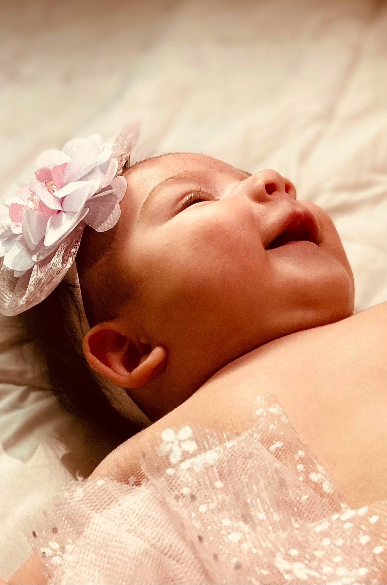 Renesmae is registered to the contest to win money with this photo: baby, baby_toddler_clothing, bridal_accessory, chin, close_up, comfort, eyebrow, eyelash, grass, happy, headgear, headpiece, linens, lip, neck, peach, person, petal, pink, skin