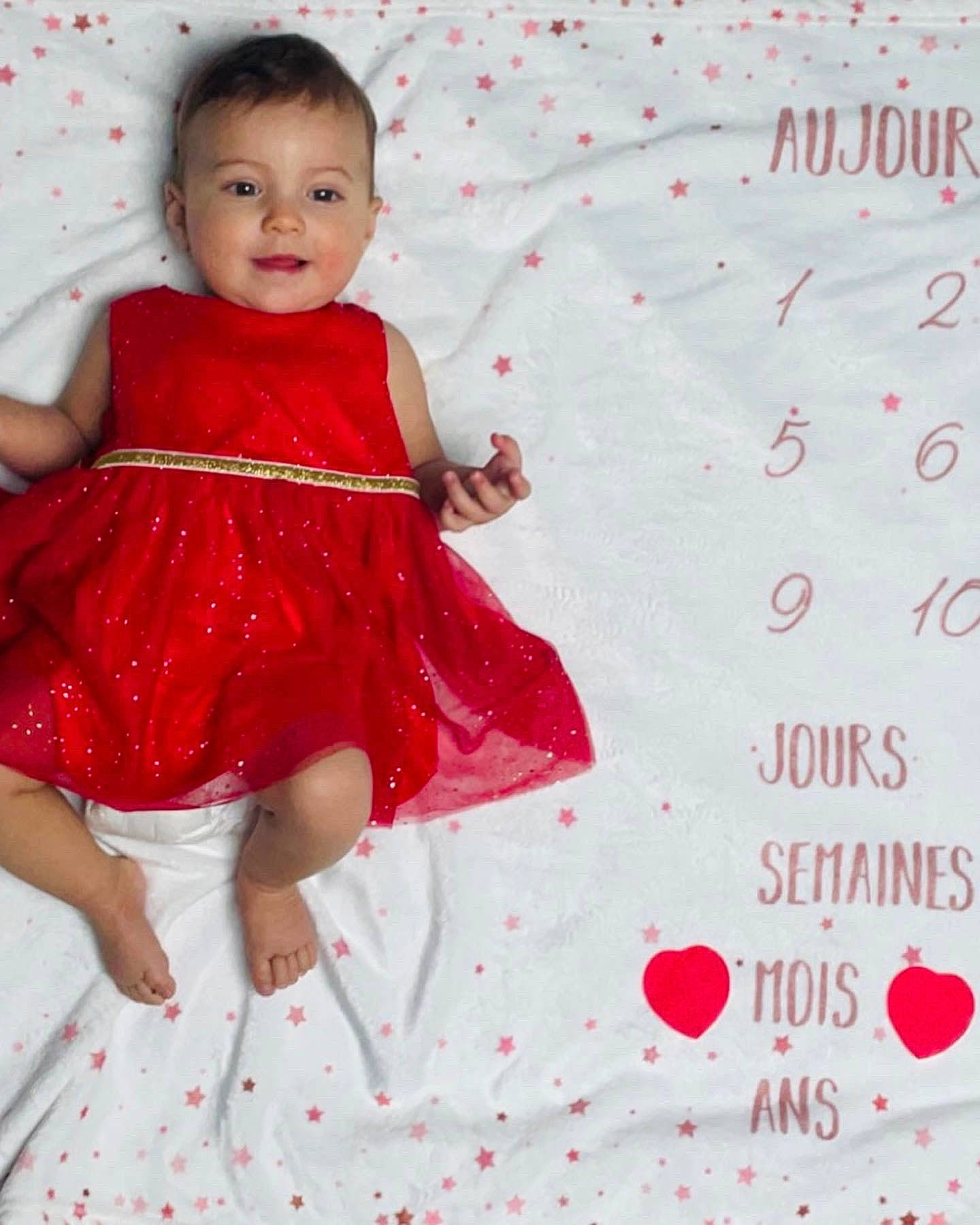 Maylee a rejoint le concours — aidez-le/la à gagner de superbes lots ! baby, baby_toddler_clothing, day_dress, dress, embellishment, event, happy, leg, magenta, one_piece_garment, pattern, person, pink, red, sitting, skin, sleeve, smile, toddler, waist