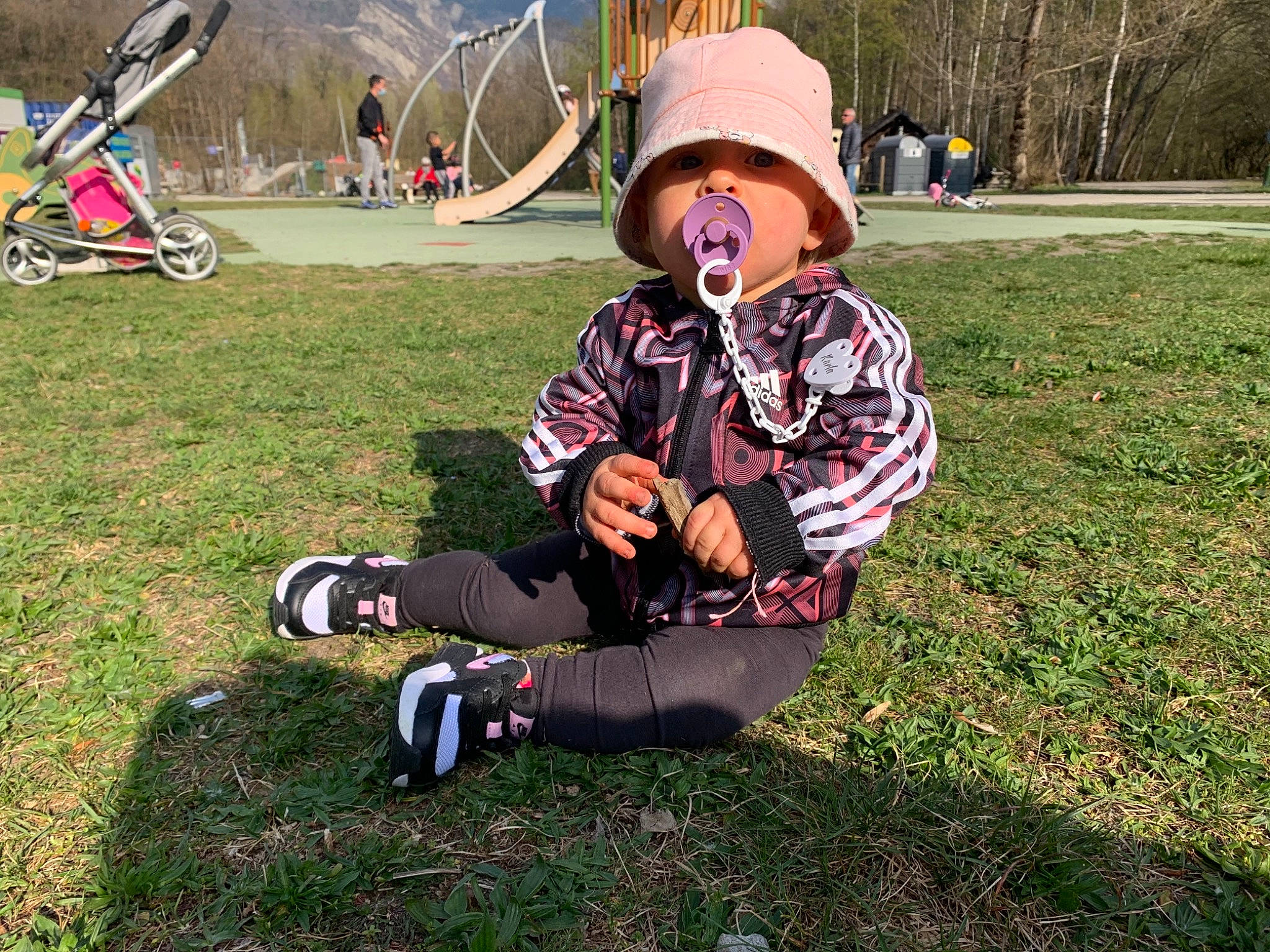 Karla participe au concours pour gagner de l'argent avec cette photo : fun, grass, grassland, hat, headwear, landscape, lawn, leisure, outdoor_recreation, person, personal_protective_equipment, plant, recreation, shoe, sitting, sneakers, spring, sun_hat, sunglasses, toddler