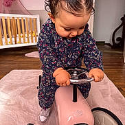 Nour a rejoint le concours — aidez-le/la à gagner de superbes lots ! baby, carpet, child, clothing, crib, curly_hair, cute, focused, furniture, grip, hair_clips, handlebars, indoor, nursery, pink, play, shoes, toddler, toy_car, wooden_floor